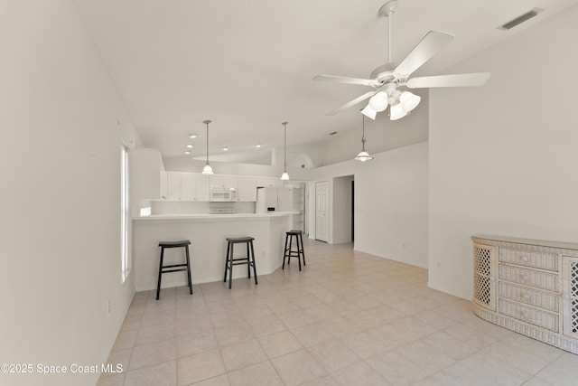1773 Sun Gazer Dr, Rockledge, FL 32955 - kitchen with a ceiling fan, a breakfast bar, white appliances, a peninsula, and white cabinetry