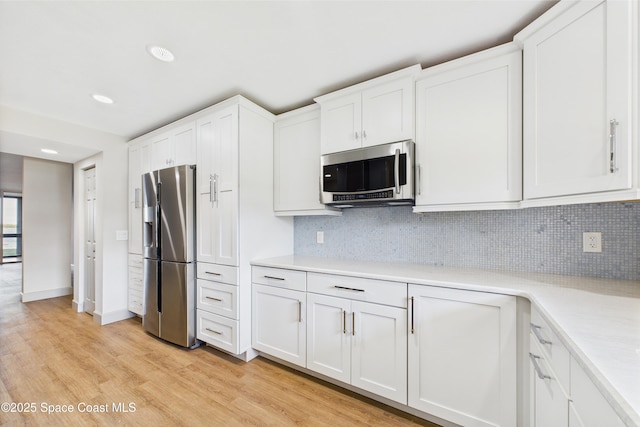 300 S Sykes Creek Pkwy Unit 106, Merritt Island, FL 32952 - kitchen featuring light countertops, white cabinets, light wood-style floors, and stainless steel appliances