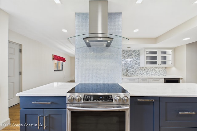 300 S Sykes Creek Pkwy Unit 106, Merritt Island, FL 32952 - kitchen with blue cabinets, island exhaust hood, stainless steel electric range oven, tasteful backsplash, and wood finished floors