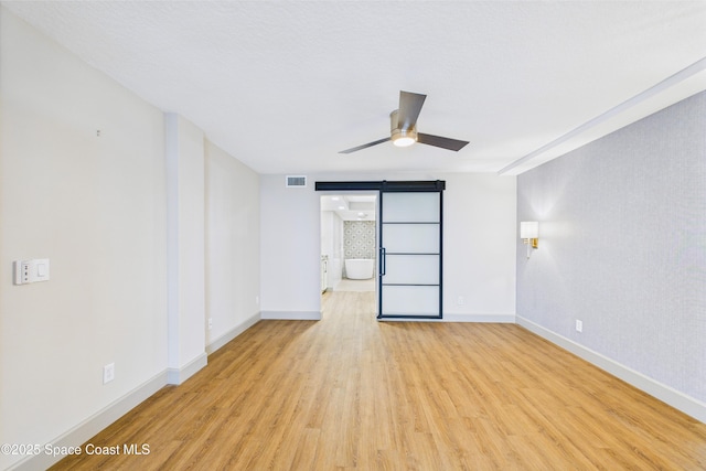 300 S Sykes Creek Pkwy Unit 106, Merritt Island, FL 32952 - empty room featuring baseboards, visible vents, a barn door, and light wood-style floors