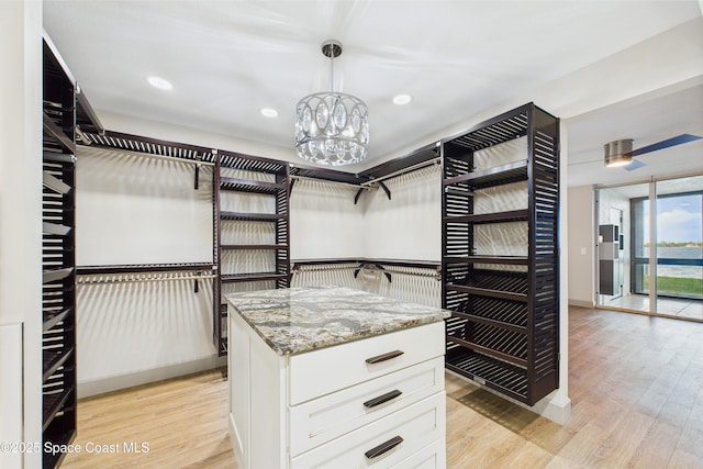 300 S Sykes Creek Pkwy Unit 106, Merritt Island, FL 32952 - walk in closet with light wood finished floors and a chandelier