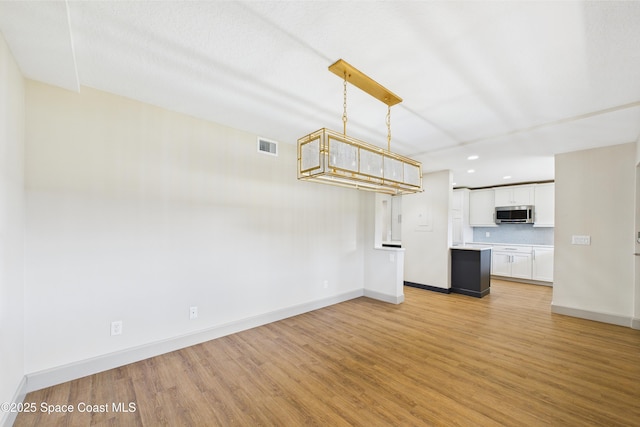 300 S Sykes Creek Pkwy Unit 106, Merritt Island, FL 32952 - unfurnished living room featuring recessed lighting, baseboards, visible vents, and light wood-style flooring