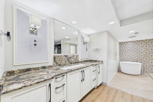 300 S Sykes Creek Pkwy Unit 106, Merritt Island, FL 32952 - bathroom with visible vents, a freestanding tub, wood finished floors, vanity, and recessed lighting