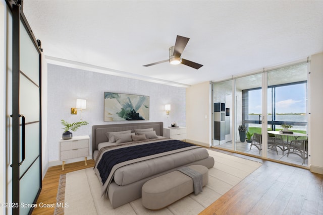 300 S Sykes Creek Pkwy Unit 106, Merritt Island, FL 32952 - bedroom featuring access to outside, light wood finished floors, baseboards, a water view, and floor to ceiling windows