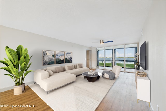 300 S Sykes Creek Pkwy Unit 106, Merritt Island, FL 32952 - living room featuring wood finished floors, floor to ceiling windows, and ceiling fan