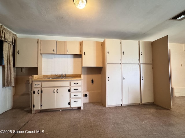 690 Lemon Grove Ave, Melbourne, FL 32904 - kitchen with backsplash, light floors, and light countertops