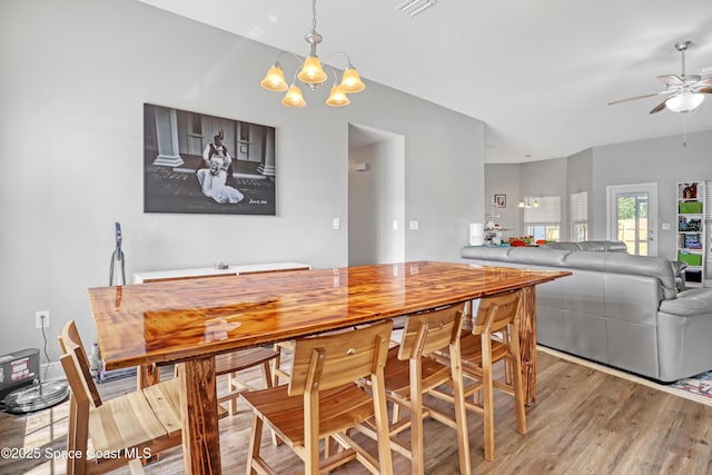 1307 Lotus St SE, Palm Bay, FL 32909 - dining area featuring light wood-type flooring, a chandelier, and a ceiling fan