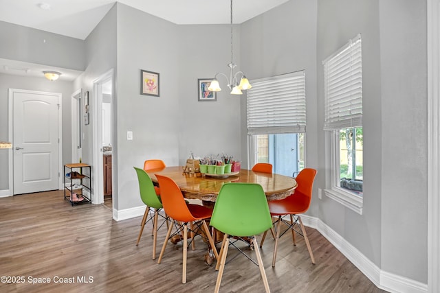 1307 Lotus St SE, Palm Bay, FL 32909 - dining area featuring a chandelier, wood finished floors, baseboards, and a high ceiling