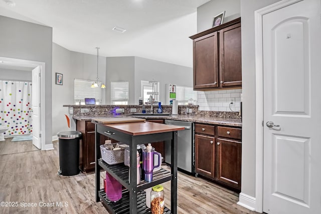 1307 Lotus St SE, Palm Bay, FL 32909 - kitchen with dishwasher, a sink, light wood-type flooring, dark brown cabinetry, and a peninsula
