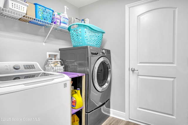 1307 Lotus St SE, Palm Bay, FL 32909 - laundry area featuring washing machine and clothes dryer, wood finished floors, and baseboards