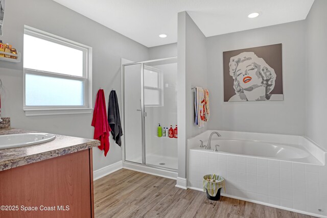 1307 Lotus St SE, Palm Bay, FL 32909 - full bath with a stall shower, wood finished floors, a garden tub, vanity, and baseboards