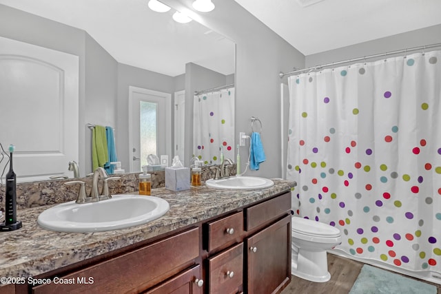 1307 Lotus St SE, Palm Bay, FL 32909 - full bath featuring wood finished floors, toilet, double vanity, and a shower with curtain
