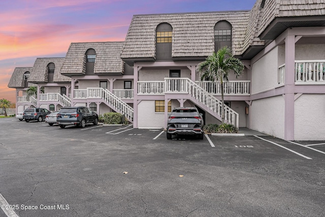5350 Ocean Beach Blvd Unit 212, Cocoa Beach, FL 32931 - view of building exterior featuring stairs and uncovered parking