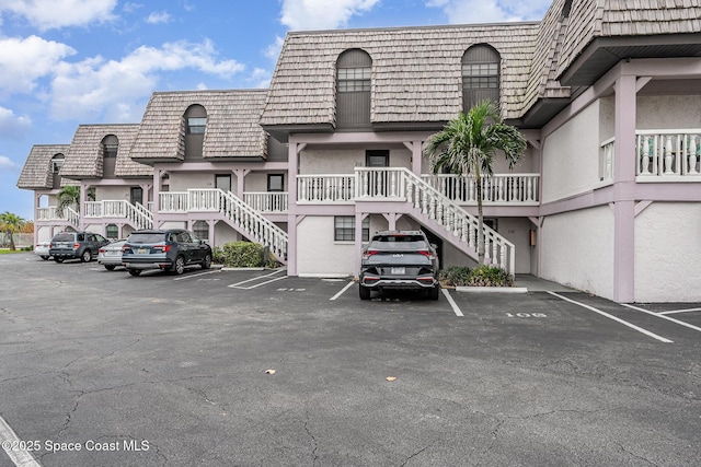 5350 Ocean Beach Blvd Unit 212, Cocoa Beach, FL 32931 - view of building exterior featuring stairway and uncovered parking