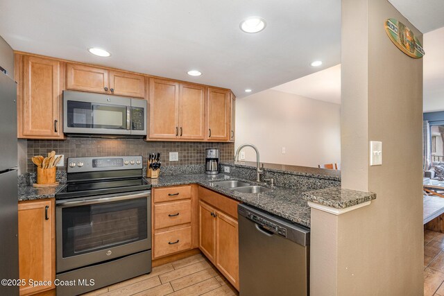 5350 Ocean Beach Blvd Unit 212, Cocoa Beach, FL 32931 - kitchen with tasteful backsplash, dark stone countertops, a sink, stainless steel appliances, and light wood finished floors
