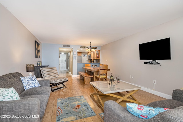 5350 Ocean Beach Blvd Unit 212, Cocoa Beach, FL 32931 - living area with light wood-type flooring, baseboards, visible vents, and an inviting chandelier