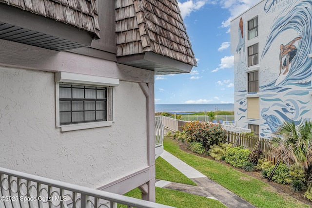 5350 Ocean Beach Blvd Unit 212, Cocoa Beach, FL 32931 - view of home's exterior featuring a water view, fence, mansard roof, and stucco siding