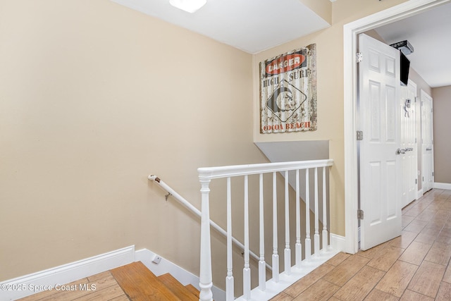5350 Ocean Beach Blvd Unit 212, Cocoa Beach, FL 32931 - hall with wood finished floors, baseboards, and an upstairs landing