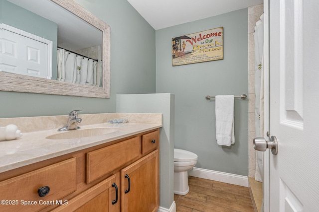 5350 Ocean Beach Blvd Unit 212, Cocoa Beach, FL 32931 - full bath with baseboards, toilet, vanity, and wood finished floors