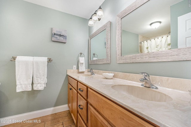 5350 Ocean Beach Blvd Unit 212, Cocoa Beach, FL 32931 - bathroom with baseboards, wood finished floors, a sink, and double vanity