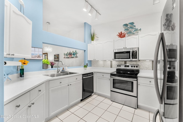 kitchen featuring decorative backsplash, white cabinetry, a sink, appliances with stainless steel finishes, and light tile patterned floors