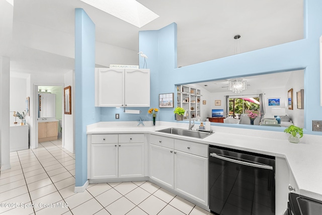 kitchen featuring light tile patterned flooring, a sink, dishwasher, light countertops, and a skylight