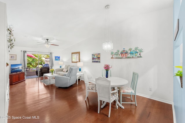 dining area featuring wood finished floors, baseboards, ceiling fan with notable chandelier, and lofted ceiling