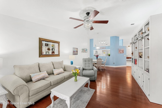 living area with visible vents, a ceiling fan, baseboards, and dark wood-style floors