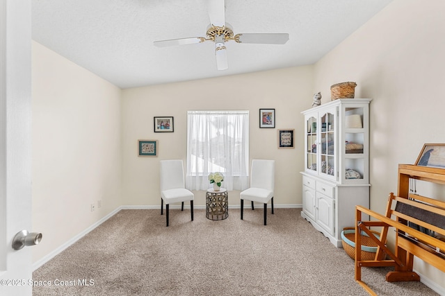 living area with carpet floors, baseboards, and ceiling fan