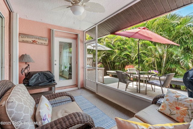 sunroom / solarium with outdoor dining area and ceiling fan
