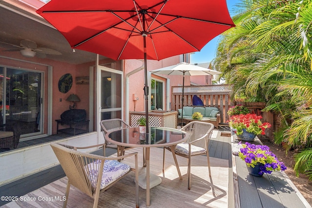 wooden terrace with fence, outdoor dining area, outdoor lounge area, and ceiling fan
