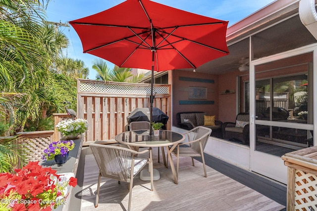 wooden deck with area for grilling, fence, and outdoor dining space