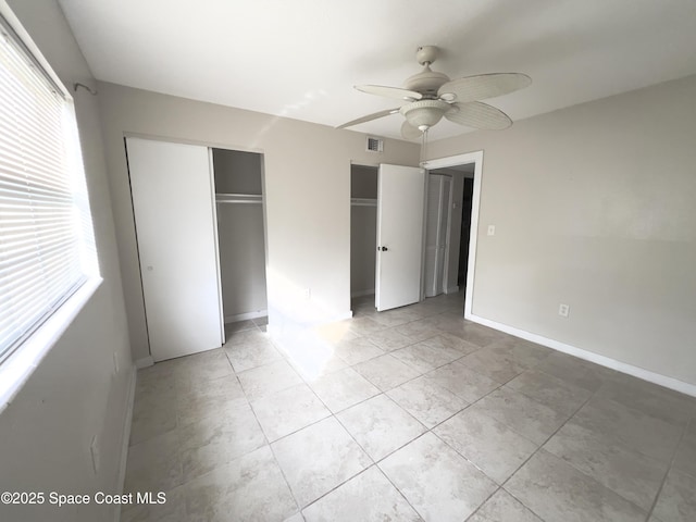 151 Ulster Ln, Melbourne, FL 32935 - unfurnished bedroom with visible vents, baseboards, light tile patterned floors, and two closets