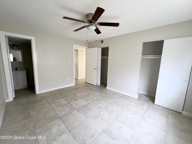 151 Ulster Ln, Melbourne, FL 32935 - unfurnished bedroom featuring two closets, a ceiling fan, baseboards, light tile patterned floors, and ensuite bathroom