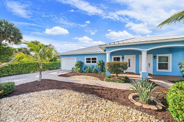 131 Harding Avenue 131& 129, Cocoa Beach, FL 32931 - view of front of property featuring a standing seam roof, stucco siding, an attached garage, driveway, and a porch