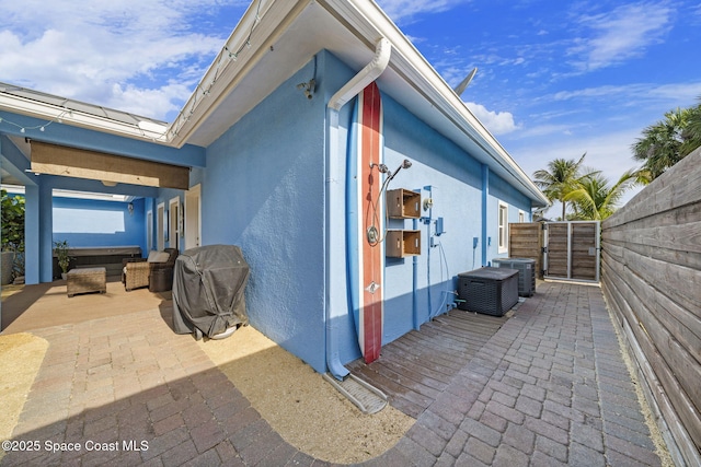 131 Harding Avenue 131& 129, Cocoa Beach, FL 32931 - view of home's exterior with a patio, a gate, stucco siding, and cooling unit
