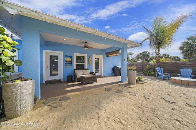 131 Harding Avenue 131& 129, Cocoa Beach, FL 32931 - back of house with ceiling fan, a patio, stucco siding, and an outdoor living space with a fire pit