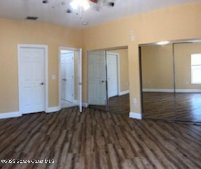 131 Harding Avenue 131& 129, Cocoa Beach, FL 32931 - unfurnished bedroom featuring wood finished floors, multiple closets, and baseboards