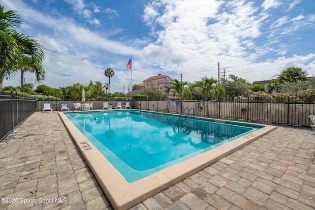 pool with a patio area and fence