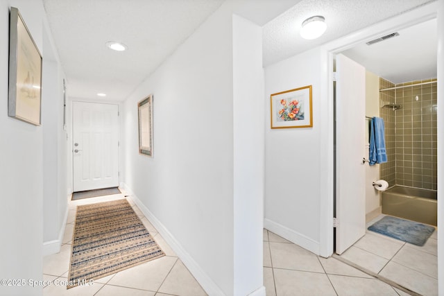 corridor with light tile patterned flooring, baseboards, visible vents, and recessed lighting