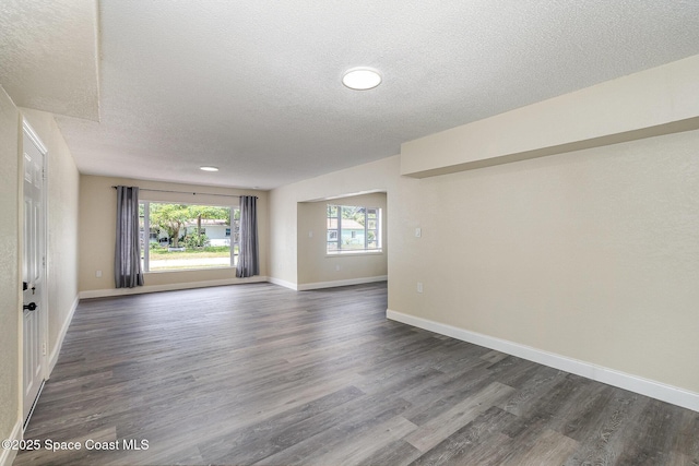 1107 Woodlawn Rd, Rockledge, FL 32955 - spare room featuring a textured ceiling, dark wood-style flooring, and baseboards