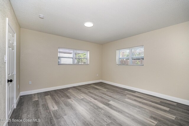 1107 Woodlawn Rd, Rockledge, FL 32955 - spare room with baseboards, wood finished floors, a textured ceiling, and plenty of natural light