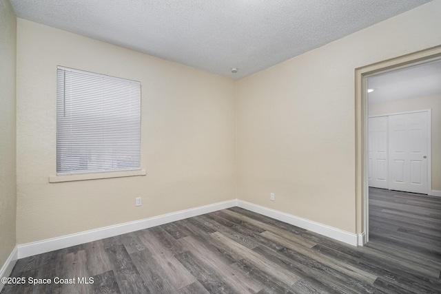1107 Woodlawn Rd, Rockledge, FL 32955 - spare room with a textured ceiling, dark wood-style floors, and baseboards