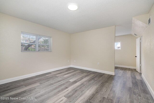 1107 Woodlawn Rd, Rockledge, FL 32955 - unfurnished room with a textured ceiling, visible vents, a wealth of natural light, and wood finished floors