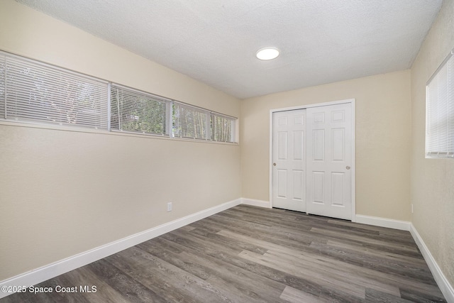 1107 Woodlawn Rd, Rockledge, FL 32955 - unfurnished bedroom with a closet, a textured ceiling, wood finished floors, and baseboards