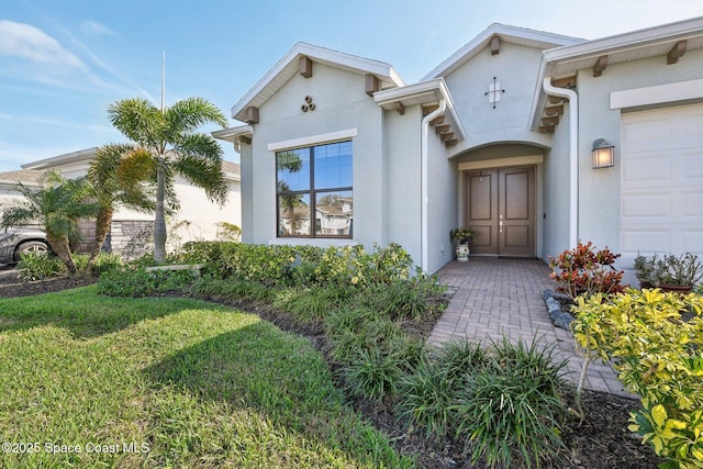 2241 Caravan Pl, Melbourne, FL 32940 - doorway to property with stucco siding and a lawn
