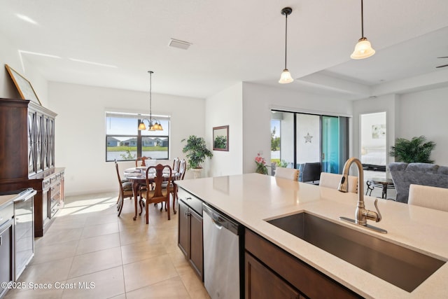 2241 Caravan Pl, Melbourne, FL 32940 - kitchen featuring dishwasher, a sink, pendant lighting, light stone countertops, and dark brown cabinets