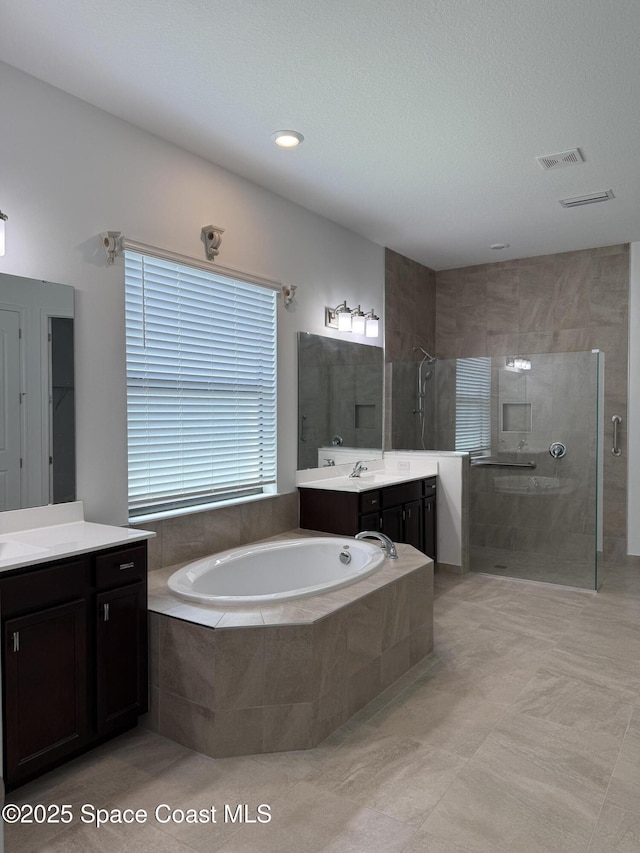 2241 Caravan Pl, Melbourne, FL 32940 - bathroom featuring a stall shower, a garden tub, vanity, and tile patterned flooring