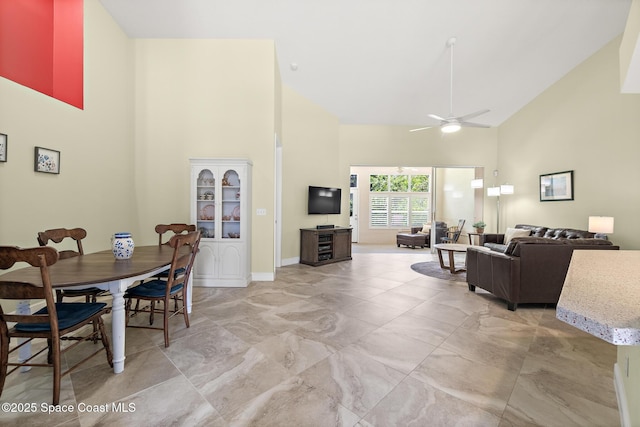 dining area featuring baseboards, high vaulted ceiling, ceiling fan, and marble finish floor