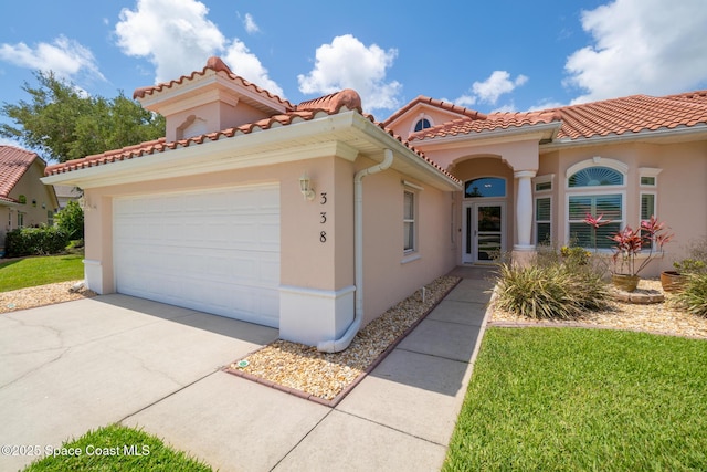 mediterranean / spanish home with stucco siding, driveway, and a garage